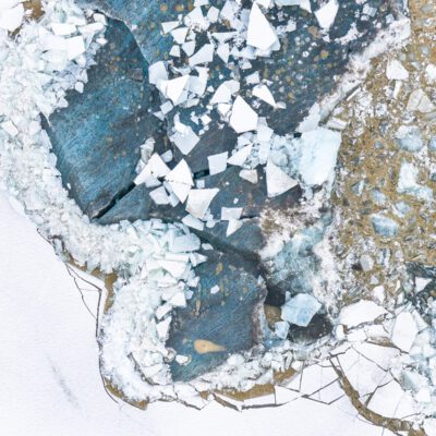 photograph of a glacier, taken from above, white and blue are dominant colours