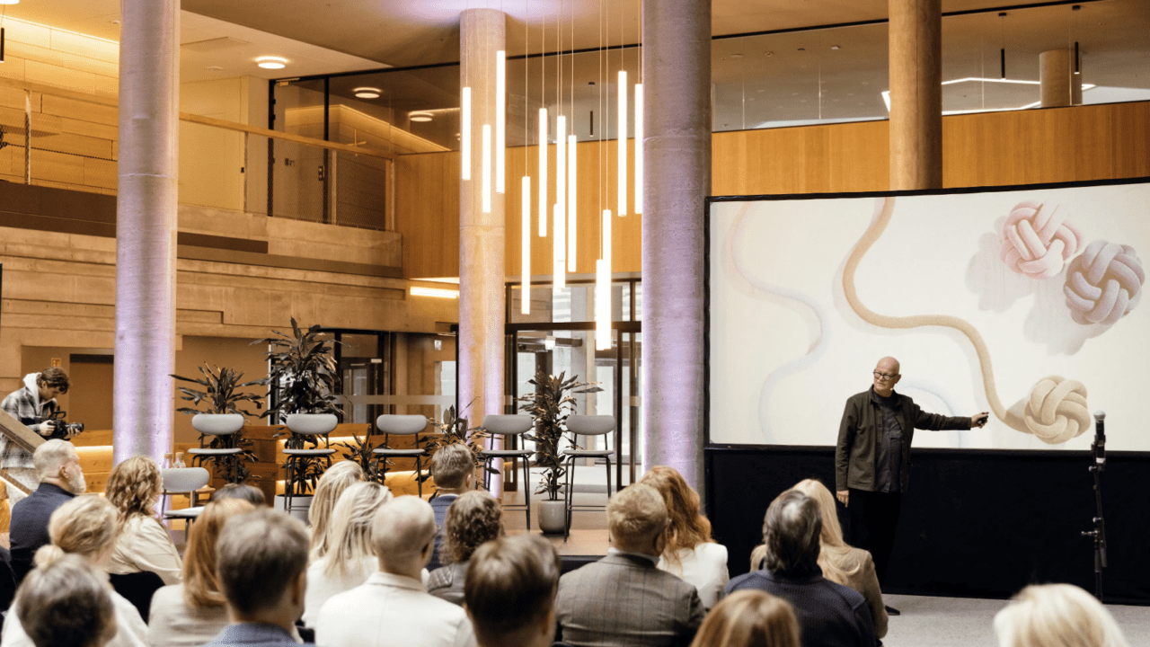 Picture of a man holding a presentation about design infront of a sitting crowd