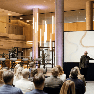 Picture of a man holding a presentation about design infront of a sitting crowd