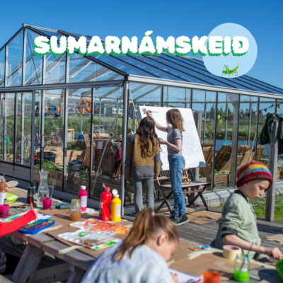 Outdoor picture of children's next to a greenhouse painting and being creative.