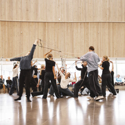 A few people performing a dance infront of sitting people