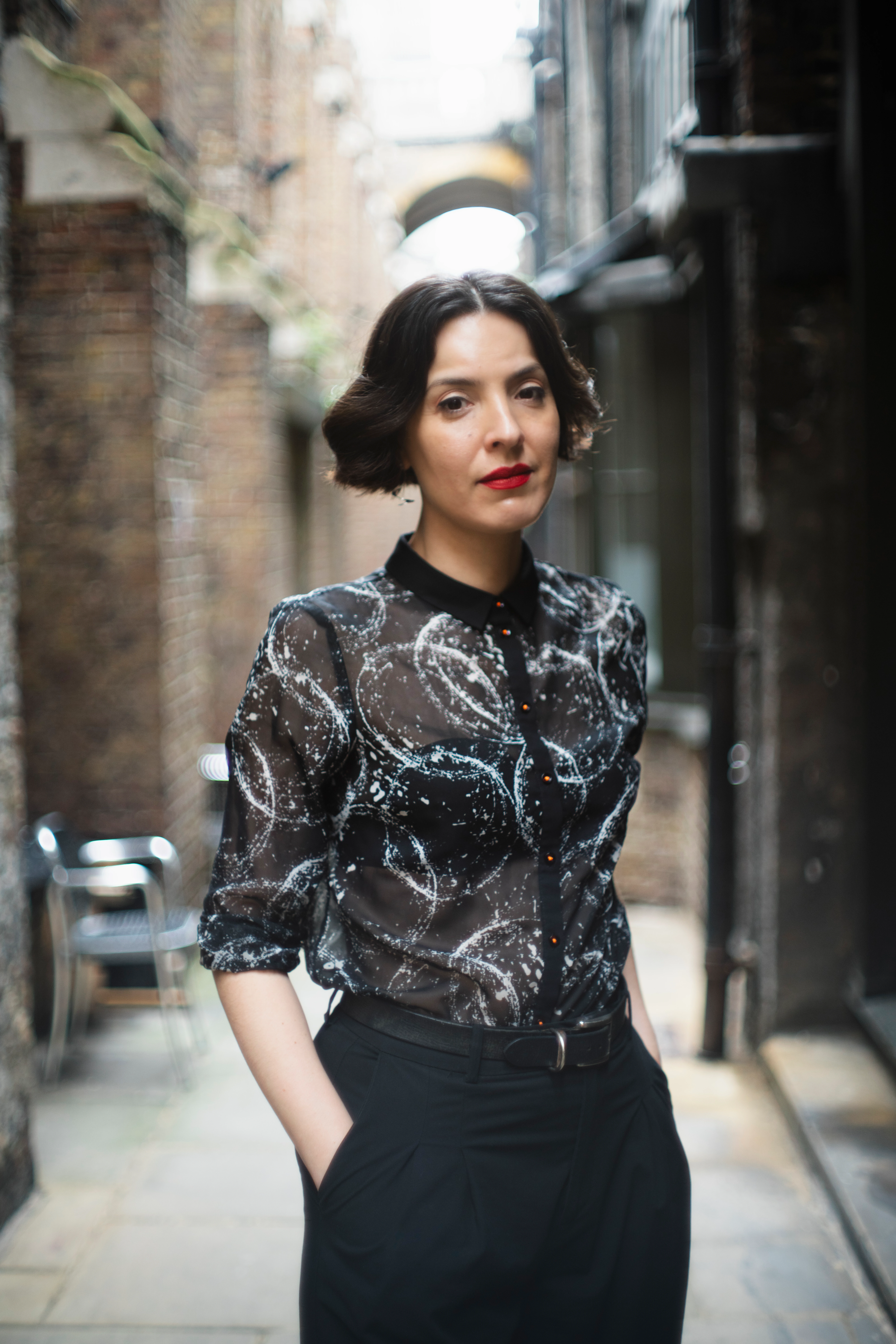 portrait of a woman. She has black middle lenght hair and red lipstick